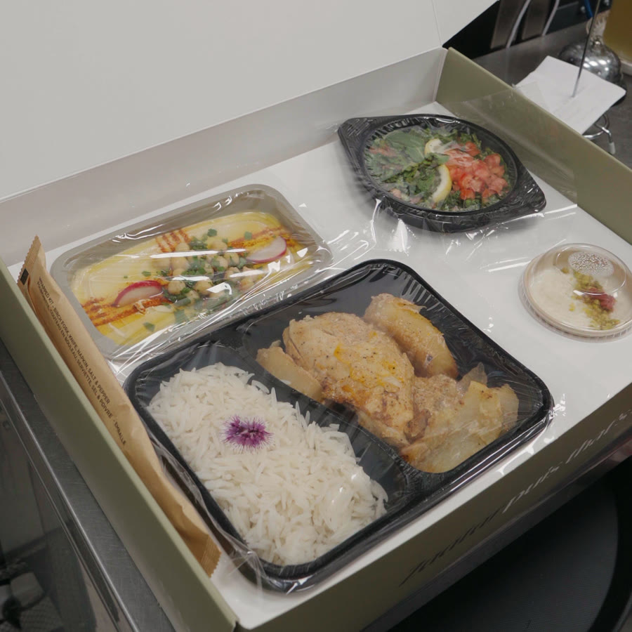 An open BÁYRŪT lunch box with hummus, salad, rice, and a handwritten Sahten min Teta note